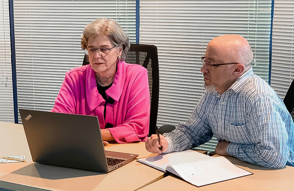 Nancy Kirby, executive director and CFO of IncubatorWorks, and Operations Manager Greg Saufley go over startup costs and a three-year projection for a client. They are working in the “Round Room,” a conference room at IncubatorWorks in Painted Post.