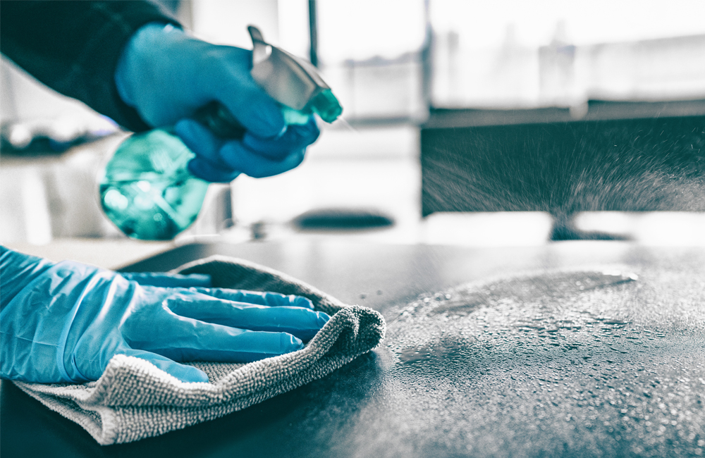 Gloved hands cleaning table