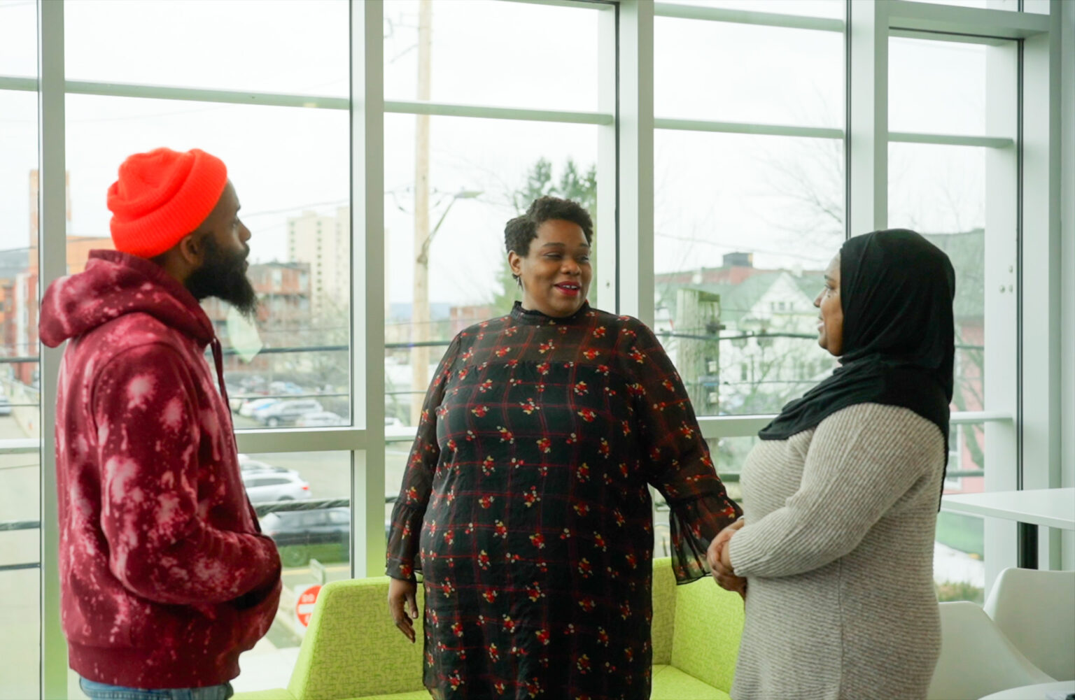 three people talking within an office like area